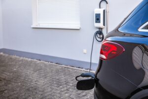 Licensed electrician installing a Level 2 home EV charging station in a Plano garage.